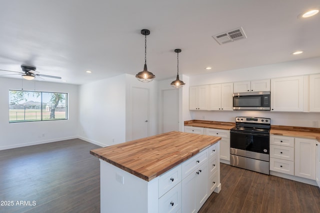 2818 E Villa Rita Dr, Phoenix, AZ 85032 - kitchen with butcher block countertops, appliances with stainless steel finishes, dark wood finished floors, white cabinets, and a ceiling fan