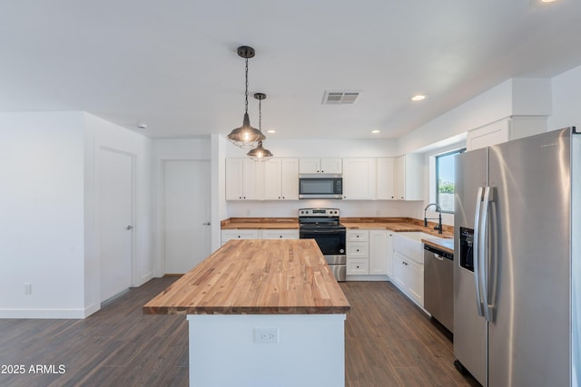 2818 E Villa Rita Dr, Phoenix, AZ 85032 - kitchen with butcher block counters, appliances with stainless steel finishes, a kitchen island, dark wood-style floors, and recessed lighting
