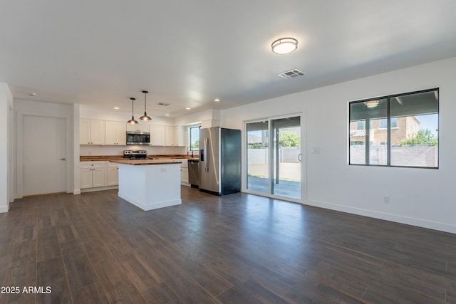 2818 E Villa Rita Dr, Phoenix, AZ 85032 - kitchen featuring stainless steel appliances, dark countertops, a center island, white cabinetry, and baseboards
