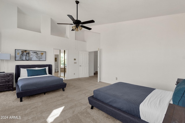 carpeted bedroom featuring a towering ceiling, a ceiling fan, and baseboards