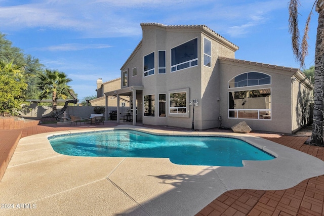 back of house with stucco siding, a fenced in pool, a patio, and a fenced backyard