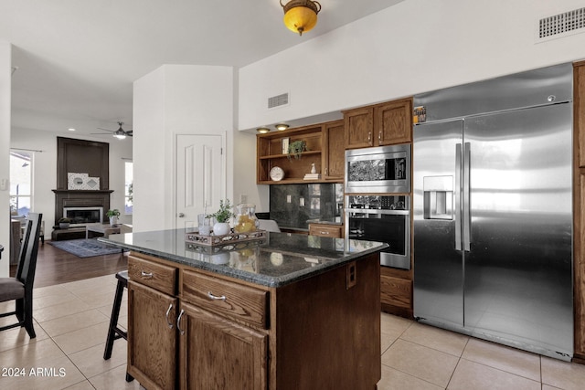 kitchen featuring light tile patterned flooring, ceiling fan, stainless steel appliances, and visible vents