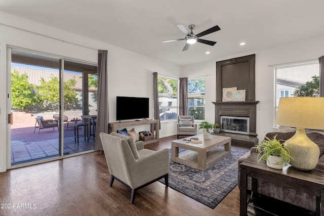 living area featuring recessed lighting, a large fireplace, ceiling fan, baseboards, and dark wood-type flooring