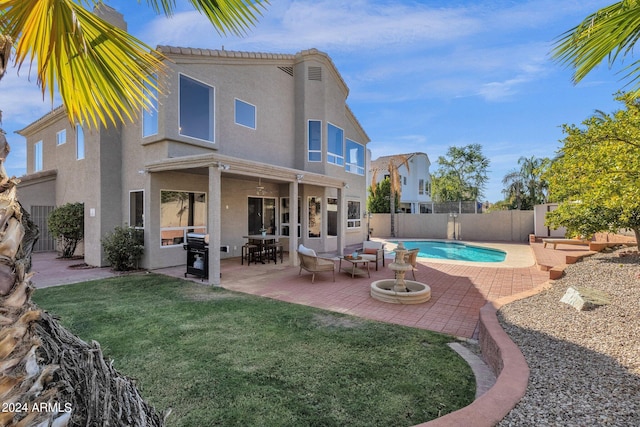 rear view of property with a patio, a fenced in pool, a fenced backyard, a lawn, and stucco siding