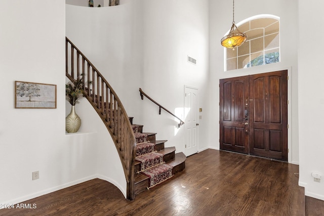 entryway with baseboards, visible vents, wood finished floors, and stairs