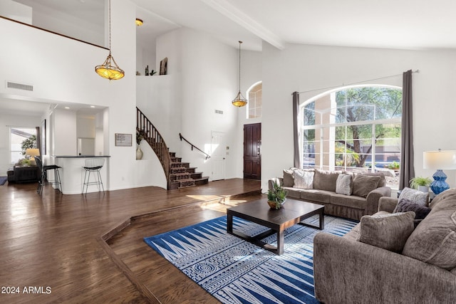 living area featuring beamed ceiling, high vaulted ceiling, stairs, visible vents, and wood finished floors
