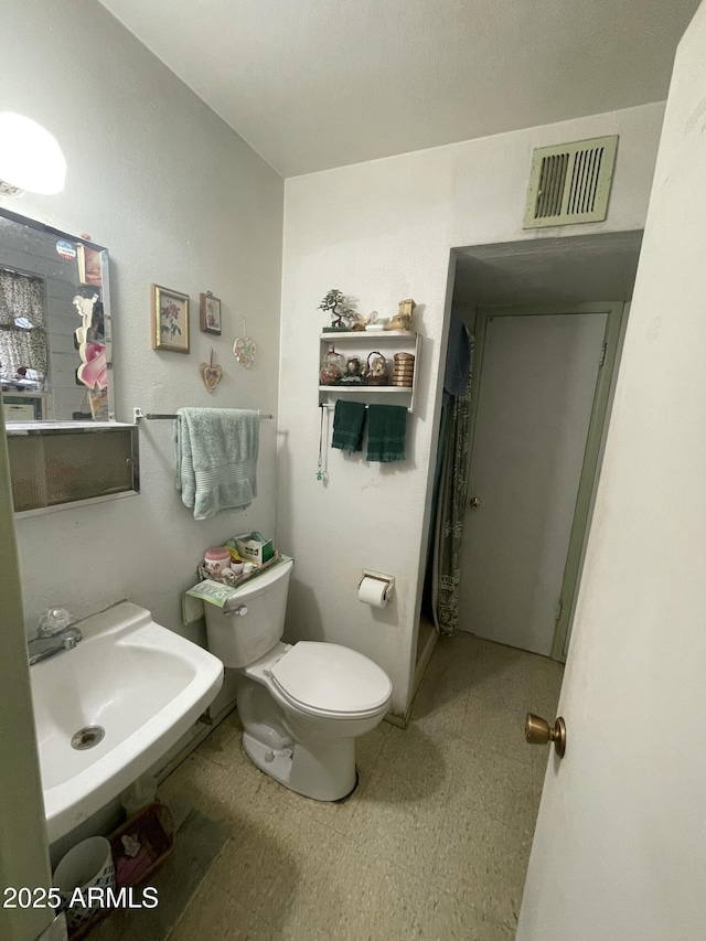 bathroom with tile patterned floors, a sink, and toilet