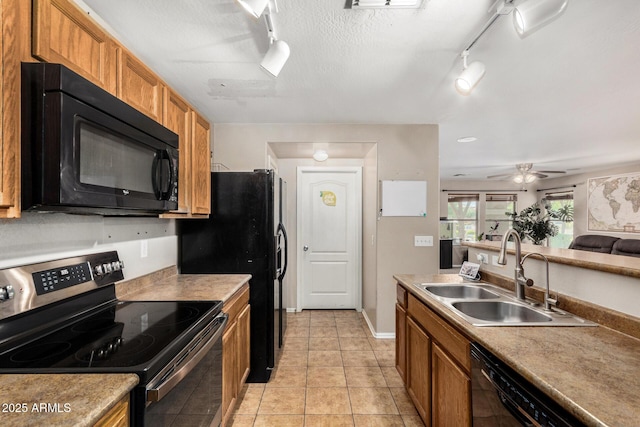 942 S Deerfield Ln, Gilbert, AZ 85296 - kitchen with black appliances, rail lighting, brown cabinetry, light tile patterned floors, and a ceiling fan