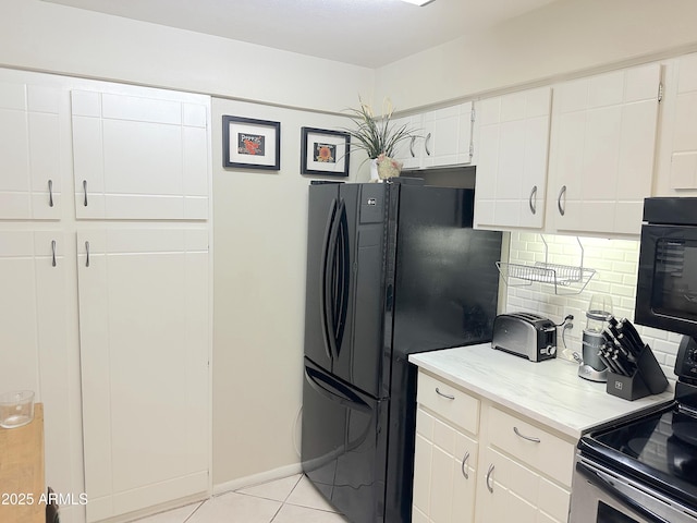 4201 E Camelback Rd Unit 51, Phoenix, AZ 85018 - kitchen with stainless steel electric range oven, freestanding refrigerator, tasteful backsplash, light tile patterned floors, and white cabinetry