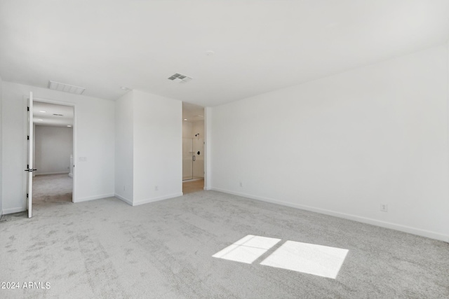 spare room featuring light colored carpet