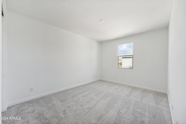 unfurnished room featuring light carpet