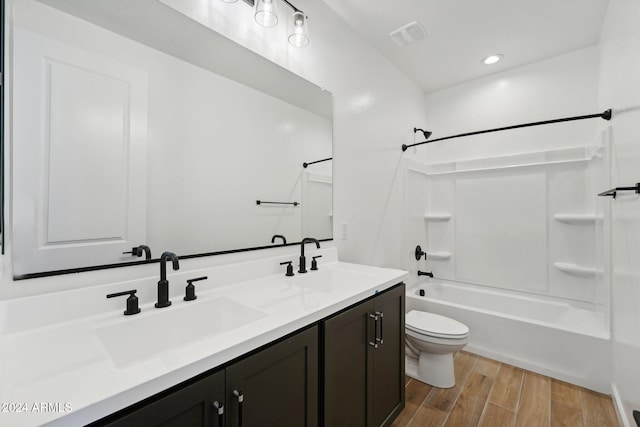 full bathroom with vanity, hardwood / wood-style flooring, bathtub / shower combination, and toilet