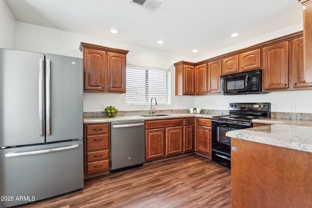 15252 N 100th St Unit 1147, Scottsdale, AZ 85260 - kitchen with black appliances, dark wood-style floors, recessed lighting, and brown cabinetry