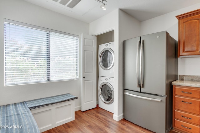 15252 N 100th St Unit 1147, Scottsdale, AZ 85260 - laundry area featuring estacked washer and dryer, light wood finished floors, healthy amount of natural light, and track lighting