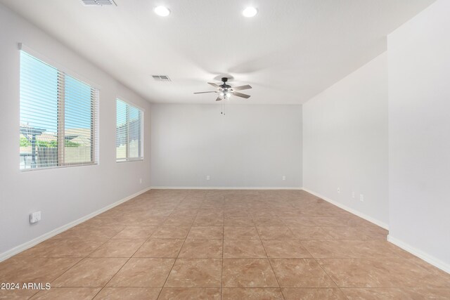 tiled spare room with ceiling fan