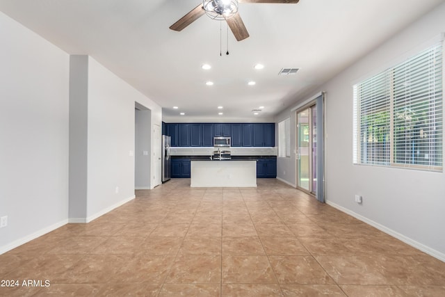 kitchen featuring light tile patterned floors, blue cabinetry, ceiling fan, and appliances with stainless steel finishes