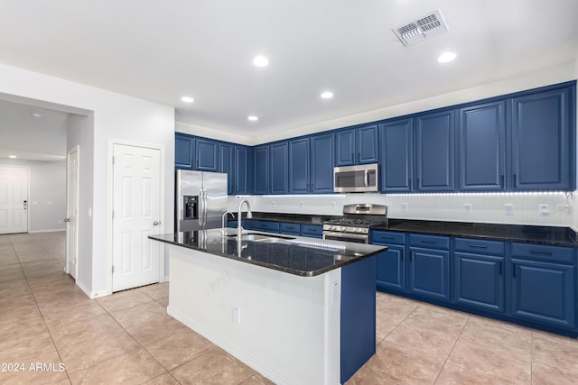 kitchen featuring blue cabinets, sink, a kitchen island with sink, light tile patterned floors, and stainless steel appliances