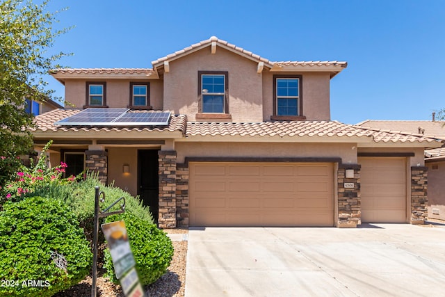 view of front of property with a garage and solar panels