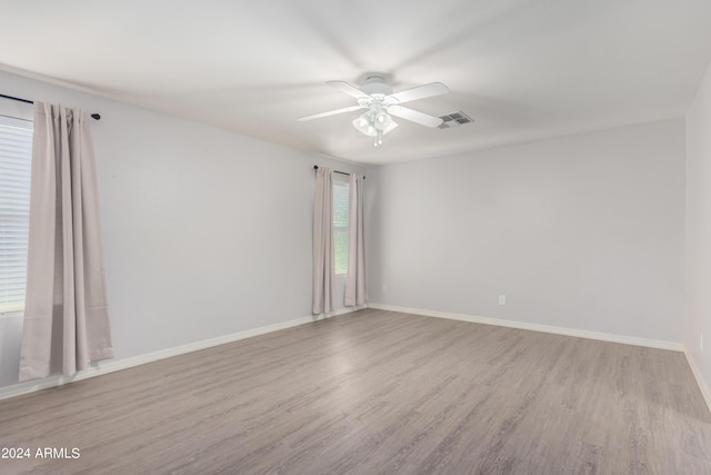 empty room featuring ceiling fan, plenty of natural light, and light hardwood / wood-style floors