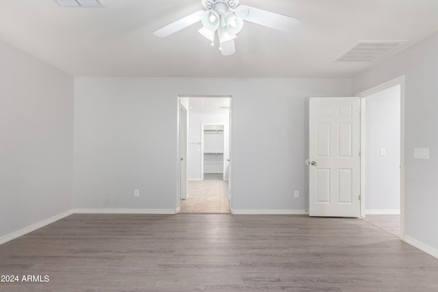 empty room with ceiling fan and light hardwood / wood-style floors