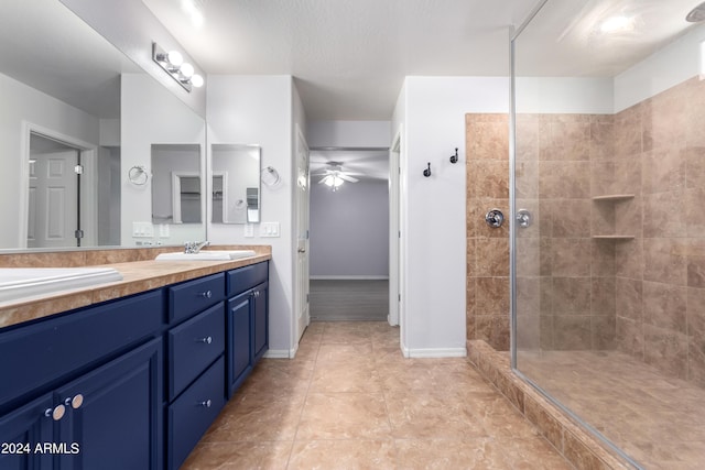 bathroom with vanity, ceiling fan, tile patterned floors, and tiled shower