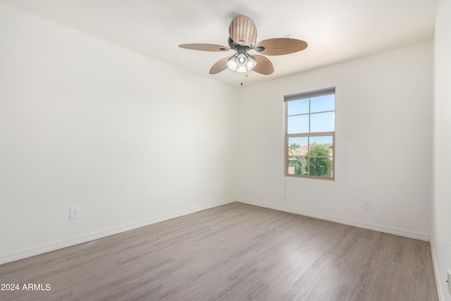 empty room with ceiling fan and light hardwood / wood-style floors