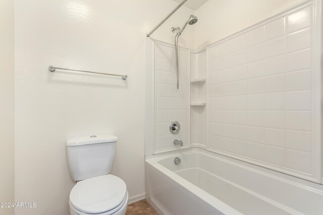 bathroom with tiled shower / bath combo and toilet