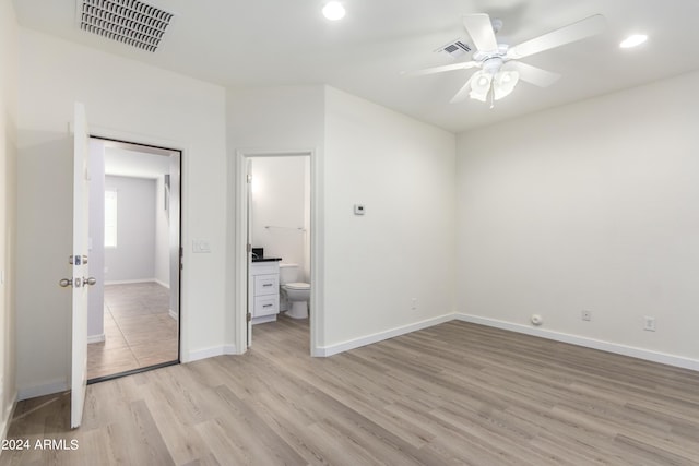 unfurnished bedroom with connected bathroom, light hardwood / wood-style floors, a closet, and ceiling fan