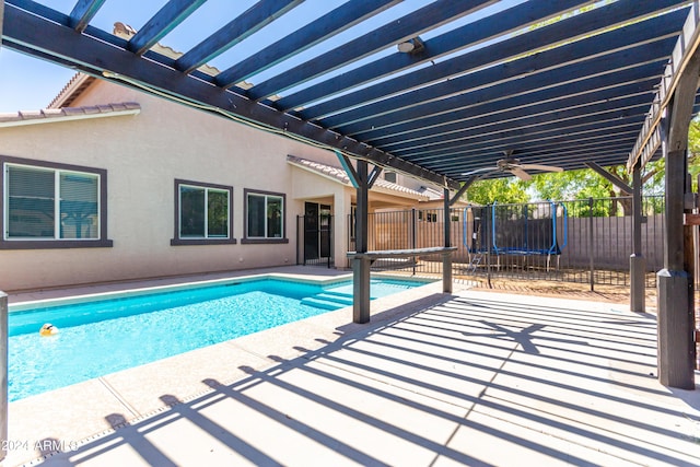 view of pool with a patio, a trampoline, ceiling fan, and a pergola