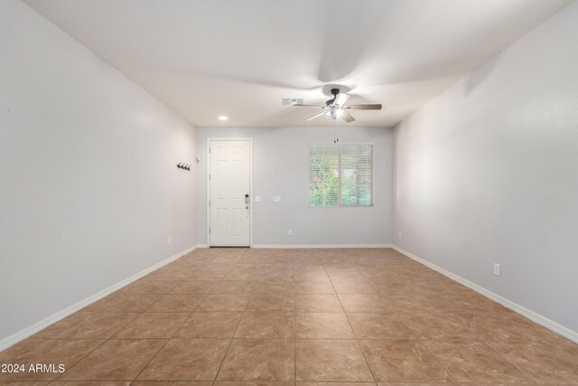 tiled spare room featuring ceiling fan