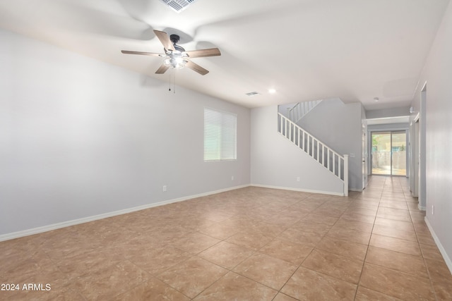 tiled empty room featuring ceiling fan