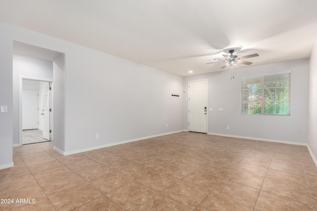 tiled spare room with ceiling fan