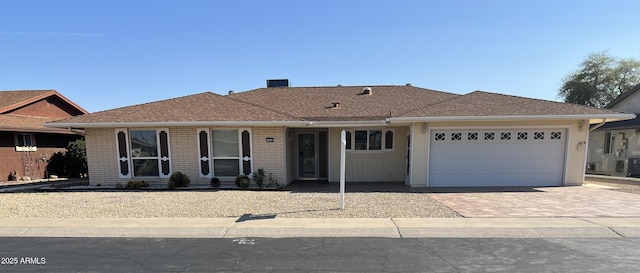 13842 N Tan Tara Dr, Sun City, AZ 85351 - ranch-style home with driveway, an attached garage, brick siding, and roof with shingles