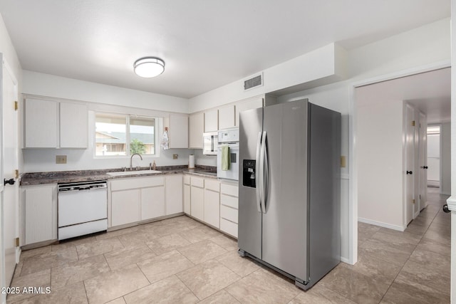13842 N Tan Tara Dr, Sun City, AZ 85351 - kitchen with visible vents, white appliances, dark countertops, white cabinetry, and a sink