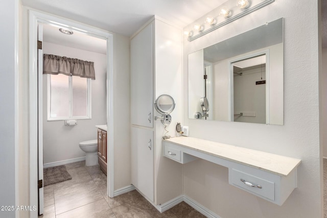 13842 N Tan Tara Dr, Sun City, AZ 85351 - bathroom with baseboards, toilet, vanity, and tile patterned floors