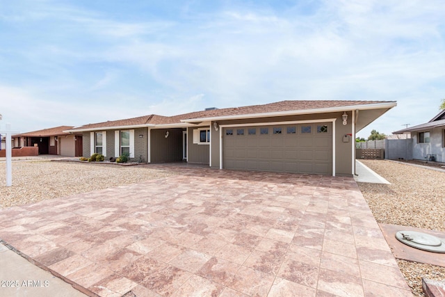 13842 N Tan Tara Dr, Sun City, AZ 85351 - ranch-style house with decorative driveway, fence, and an attached garage