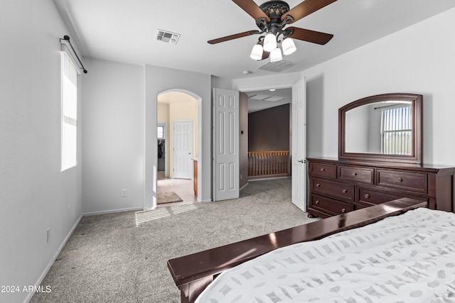 unfurnished bedroom with light carpet, multiple windows, and ceiling fan