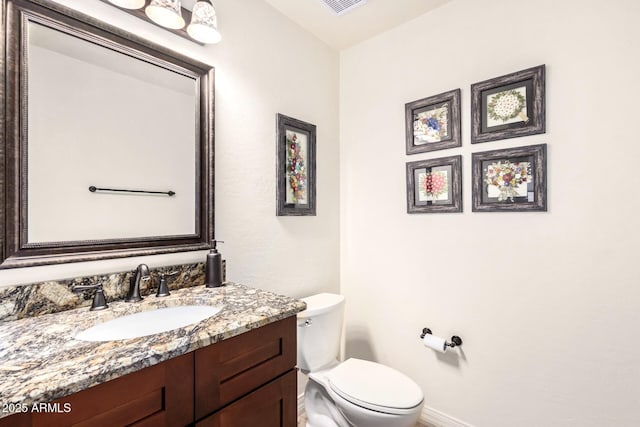 bathroom featuring toilet and vanity