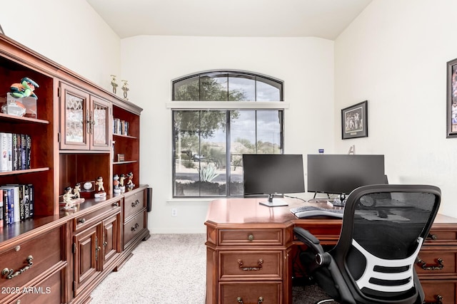 office space with vaulted ceiling and light carpet