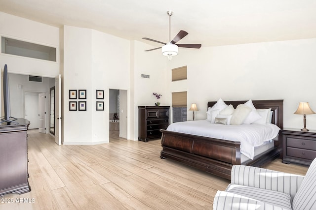 bedroom featuring high vaulted ceiling, visible vents, and light wood-type flooring