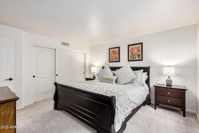 bedroom with baseboards, visible vents, a closet, and light carpet