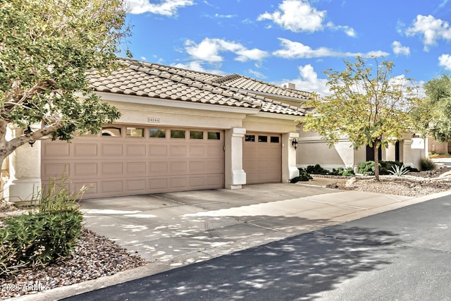 view of front facade featuring stucco siding, a garage, concrete driveway, and a tile roof