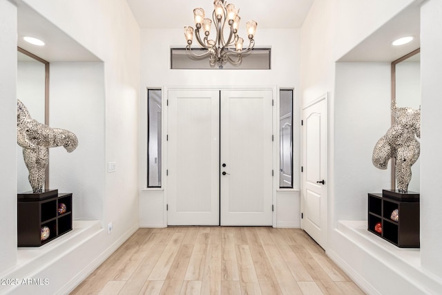 foyer featuring recessed lighting, wood finished floors, baseboards, and a chandelier