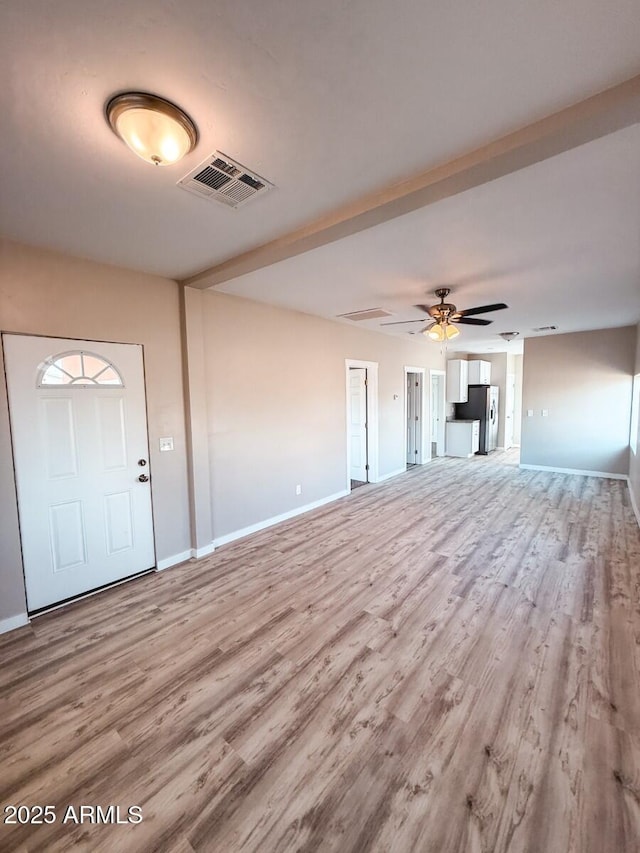 unfurnished living room with ceiling fan, light wood finished floors, visible vents, and baseboards