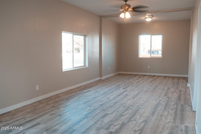 spare room with ceiling fan, wood finished floors, visible vents, and baseboards