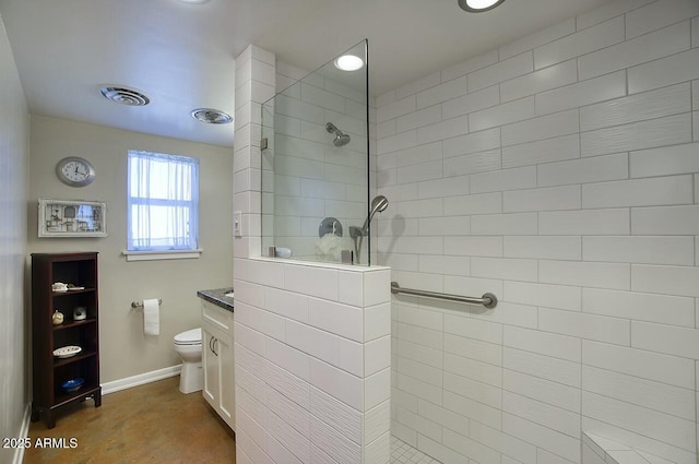 bathroom featuring toilet, vanity, visible vents, baseboards, and walk in shower