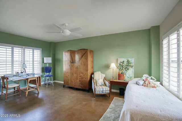 bedroom with a ceiling fan, multiple windows, concrete floors, and baseboards