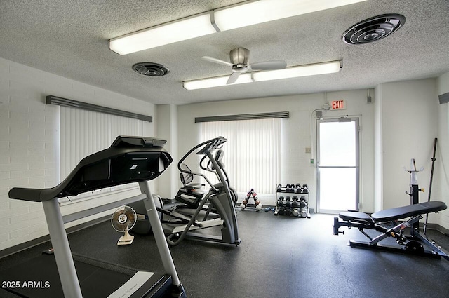 exercise room with visible vents, ceiling fan, and a textured ceiling