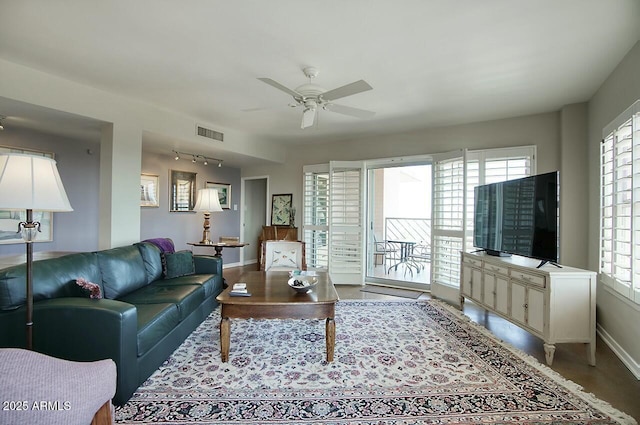 living room featuring visible vents, ceiling fan, and baseboards