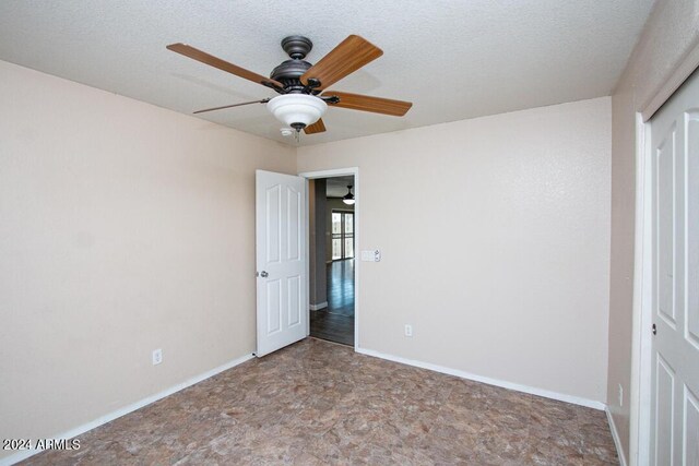 unfurnished bedroom featuring a textured ceiling, ceiling fan, and a closet